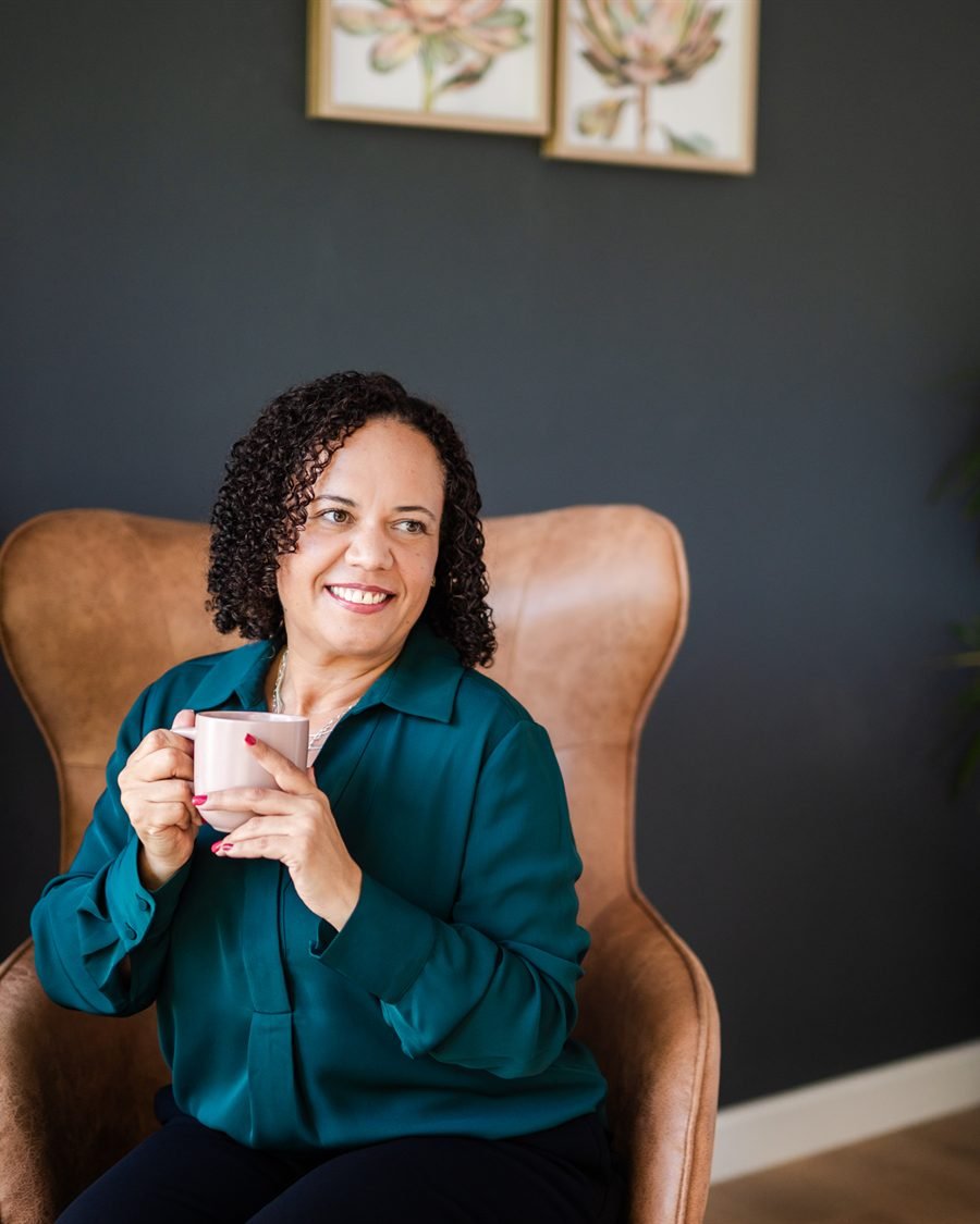 Alicia Noble, seated with a cup of coffee